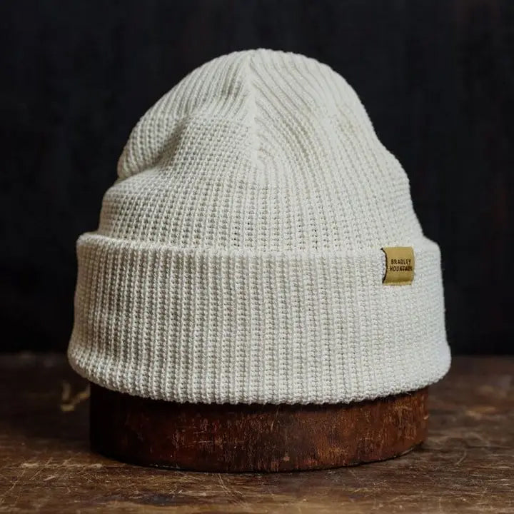 Soft bone-colored knit beanie with a folded brim, combining cozy warmth and clean, versatile style