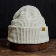 Soft bone-colored knit beanie with a folded brim, combining cozy warmth and clean, versatile style