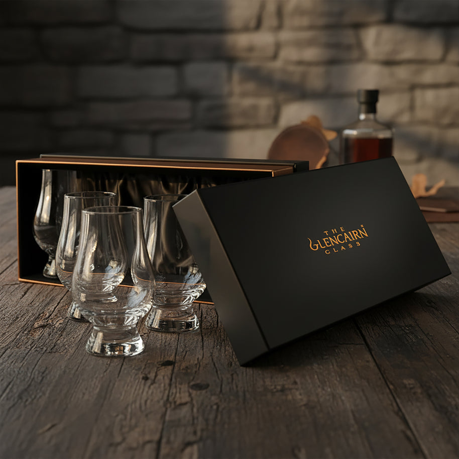 Set of Glencairn whisky glasses with a black box on a wooden surface.