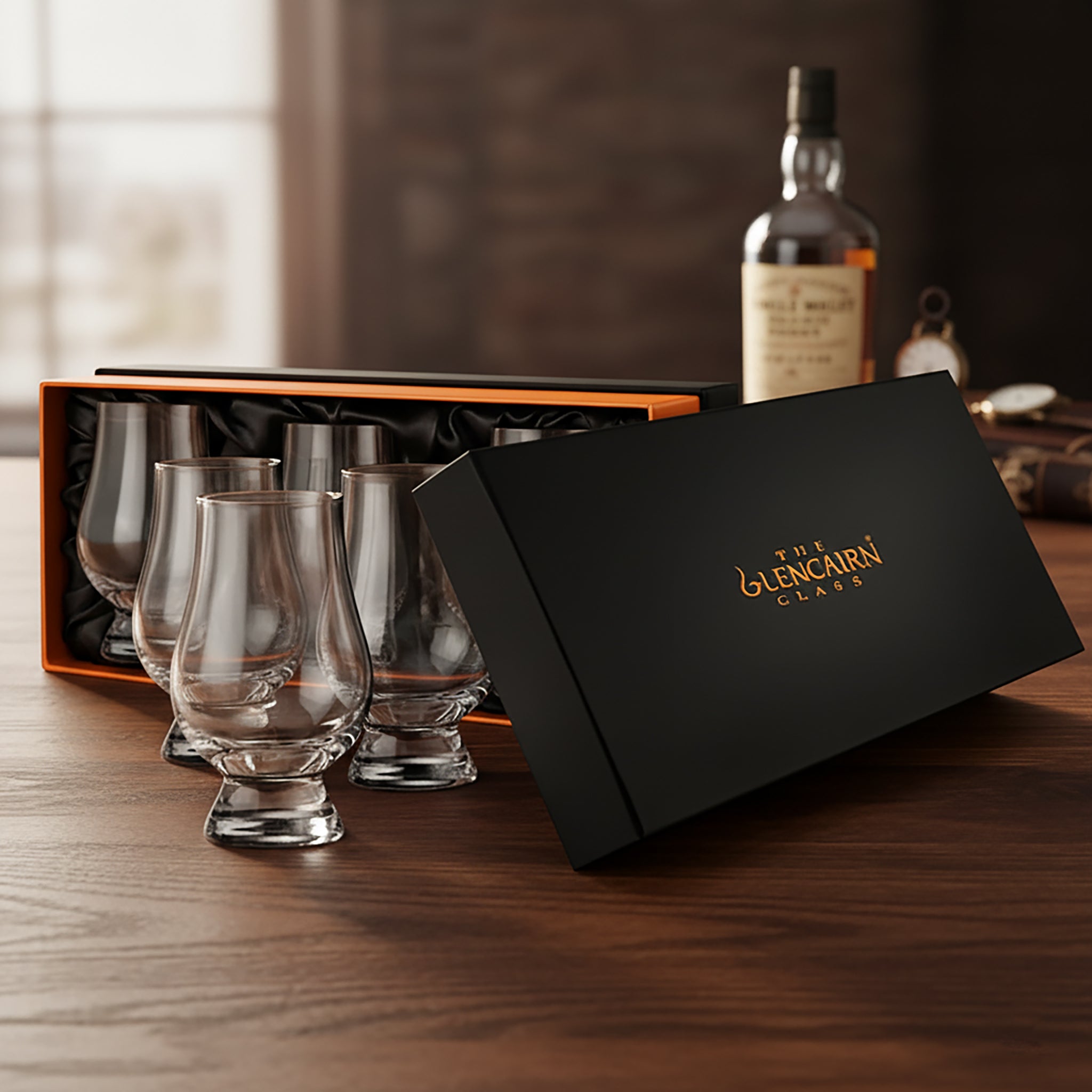 Set of Glencairn whisky glasses with a black box on a wooden surface, featuring the Glencairn logo.