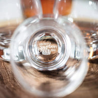 Close-up of a whiskey glass base engraved with “Kentucky Bourbon Trail,” adding a distinctive, authentic detail