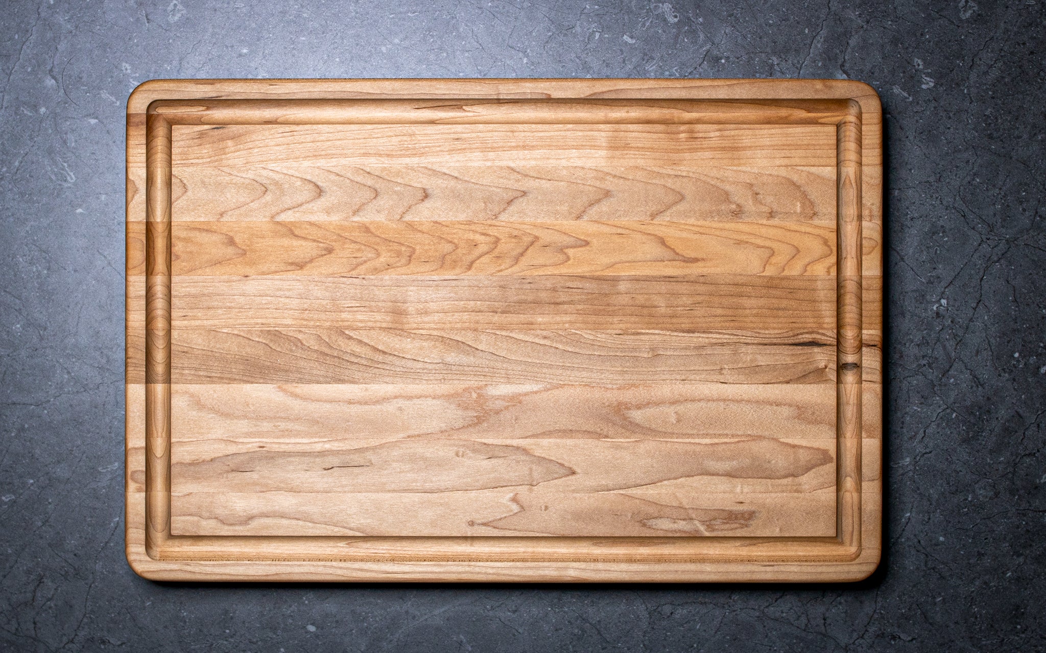 Wooden cutting board on a dark gray surface