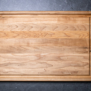 Wooden cutting board on a dark gray surface