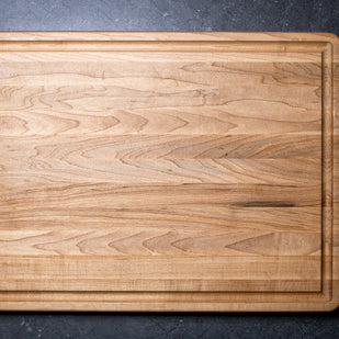 Wooden cutting board on a dark gray surface
