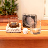 Whiskey glass with granite chilling base and stone insert, shown alongside an empty glass and spare base for display