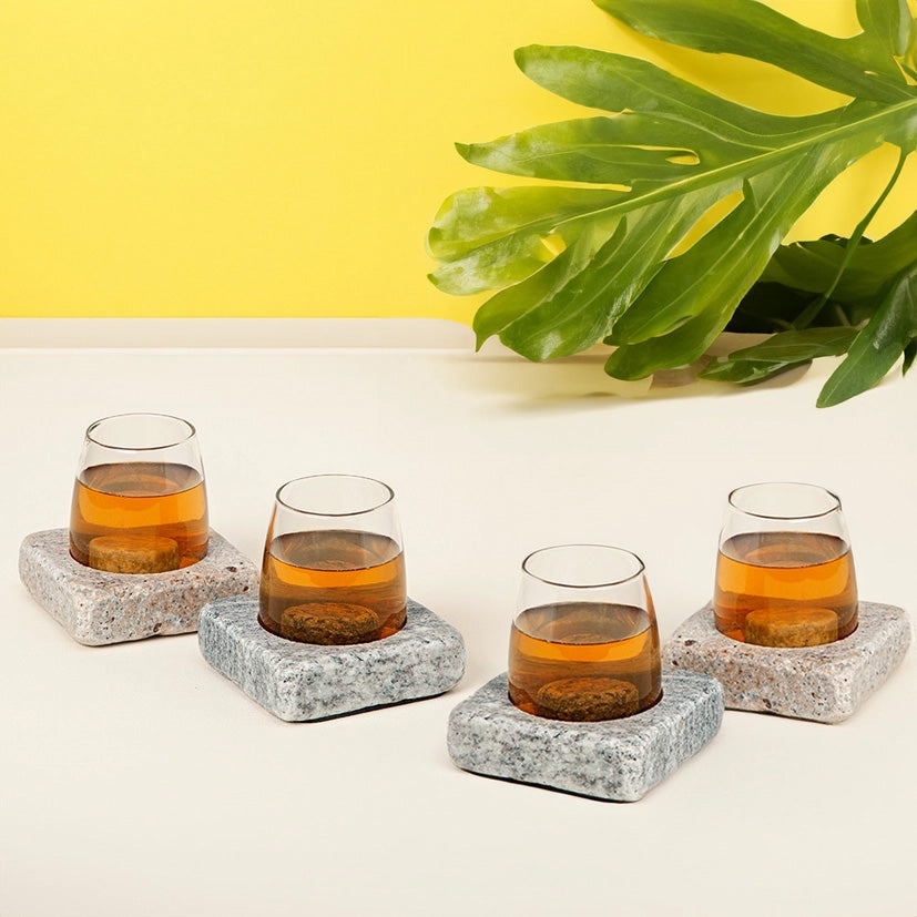 Set of four glasses in square stone bases with chilling rocks, keeping drinks cool in a modern, rustic presentation
