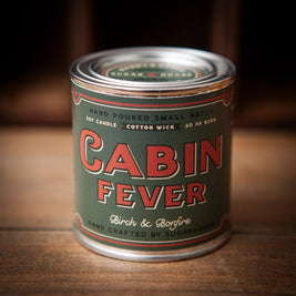 Cabin Fever soy candle in vintage paint-can style tin. Label reads ‘Cabin Fever – Birch & Bonfire.’ Hand-poured small batch with cotton wick, 40-hour burn. Handcrafted by Sugarhouse