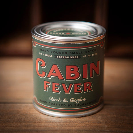 Cabin Fever soy candle in vintage paint-can style tin. Label reads ‘Cabin Fever – Birch & Bonfire.’ Hand-poured small batch with cotton wick, 40-hour burn. Handcrafted by Sugarhouse