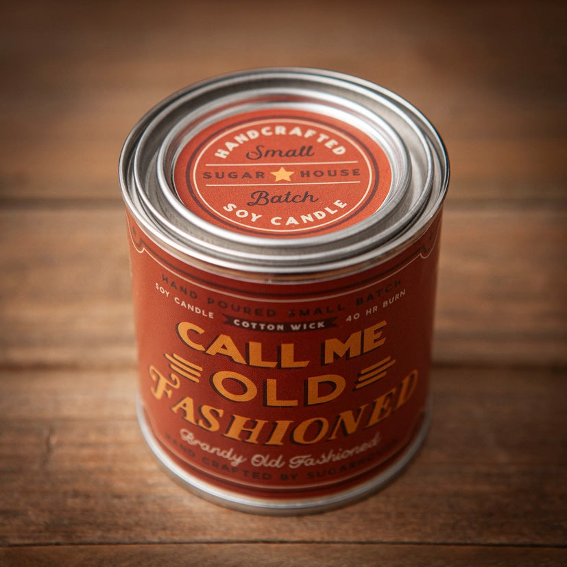 Sugarhouse candle tin with a bold red-orange label and silver lid. The label reads “Handcrafted Small Batch Soy Candle,” “Call Me Old Fashioned,” and “Brandy Old Fashioned.” Additional details note “Hand Poured Small Batch,” “Cotton Wick,” and “40 HR Burn.”