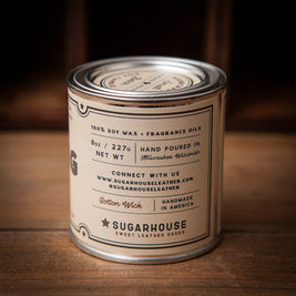 Back label of a Sugarhouse soy candle tin in cream color. Text reads “100% Soy Wax + Fragrance Oils,” “8oz / 227g,” “Hand Poured in Milwaukee, Wisconsin.” Includes contact info, “Cotton Wick,” “Handmade in America,” and “Sugarhouse Sweet Leather Goods