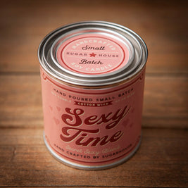 Pink Sugarhouse soy candle labeled “Sexy Time – Secret Sexy Blend,” in a tin can with a vintage-style design and metal lid, placed on a wooden surface