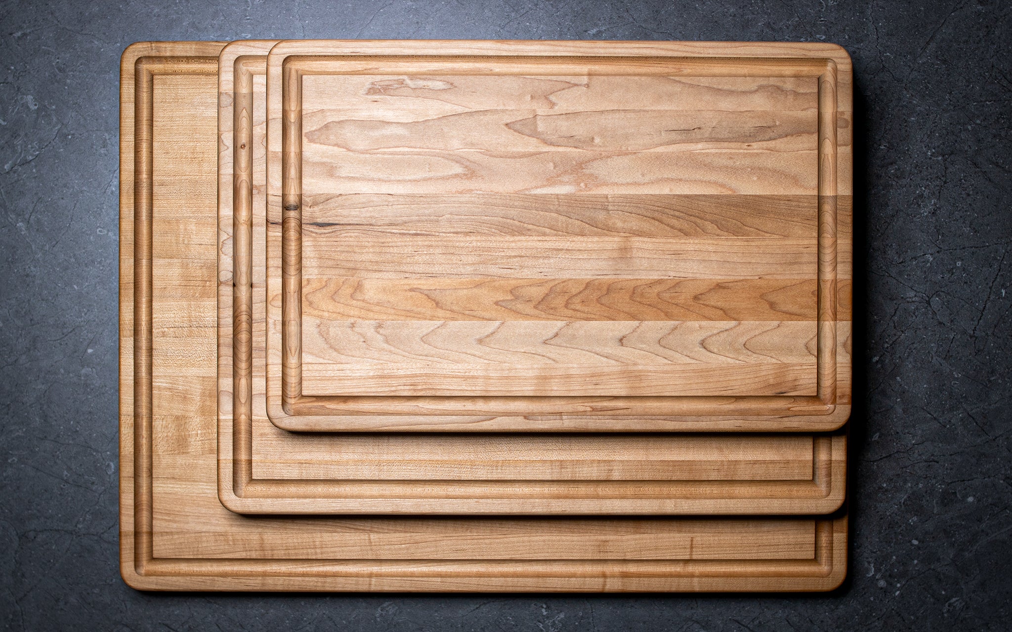 Set of wooden cutting boards on a dark surface