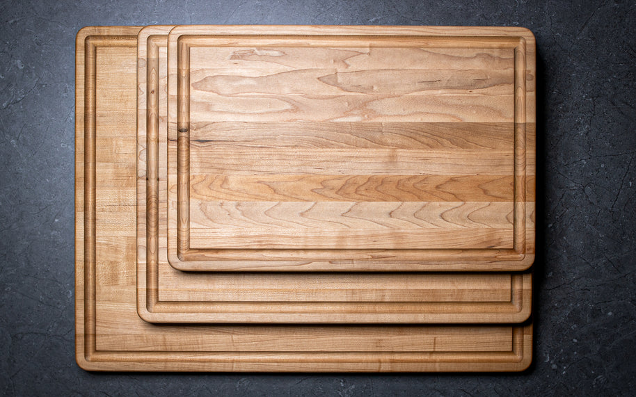 Set of wooden cutting boards on a dark surface