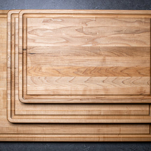 Set of wooden cutting boards on a dark surface