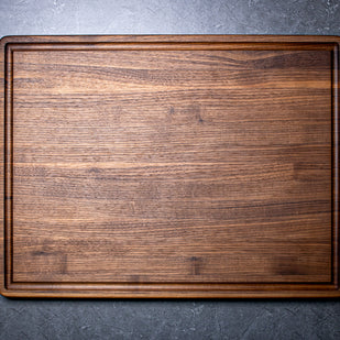 Wooden cutting board on a dark gray surface