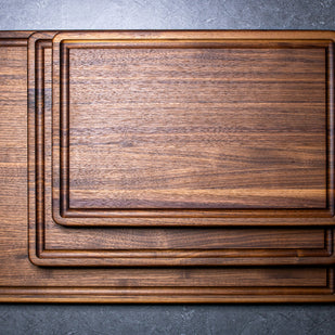 Stack of wooden cutting boards on a gray surface